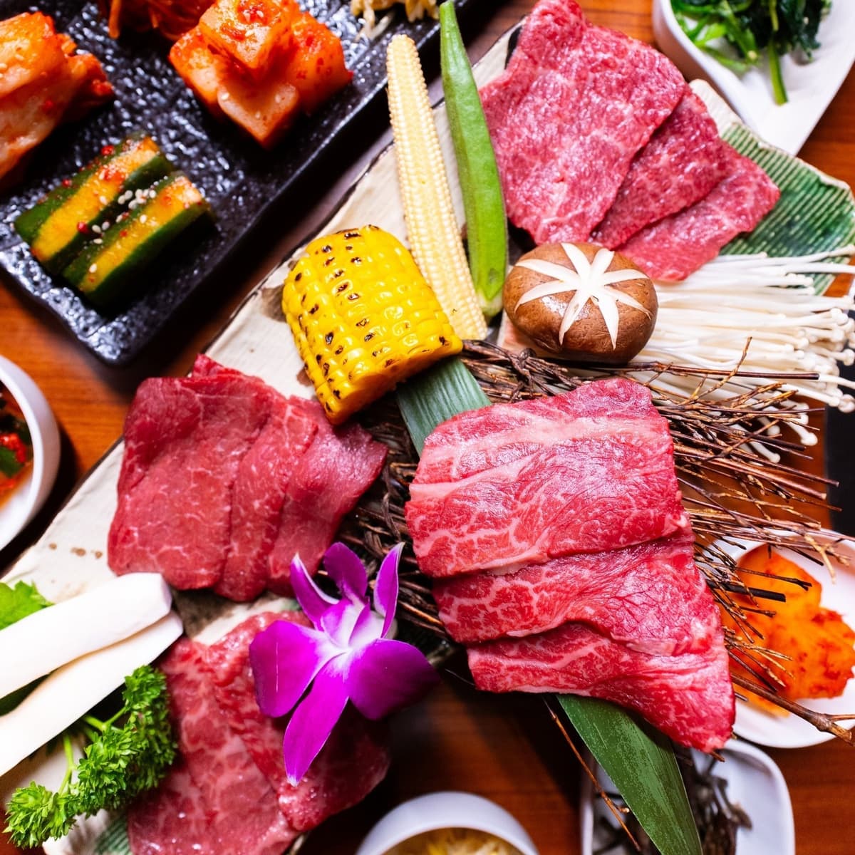 牛肉や野菜、キムチ、ナムルを並べた焼肉盛り合わせのテーブル写真