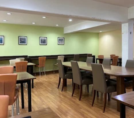 店内：木目を基調としたまんが喫茶 & レストラン Órange Houseのテーブル席