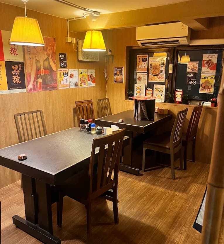 TAKAKIの店内。テーブル席が並ぶ落ち着いた和風中華居酒屋