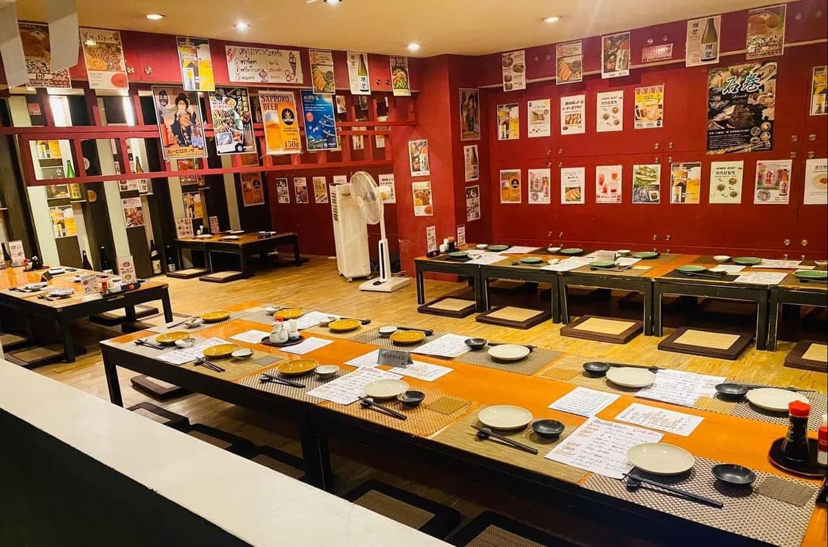 日本の居酒屋らしいポスターが並ぶ「鮨 郷土居酒屋 三陸」の広々とした座敷席
