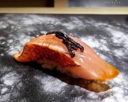 炙り魚の握り寿司を黒い器に盛り付けた一品