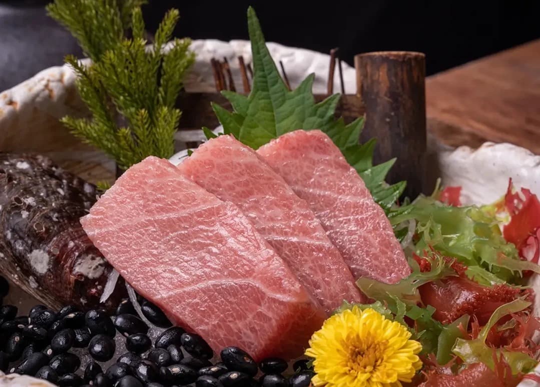 大葉や菊の花を添えた脂ののった本マグロの大トロ刺身