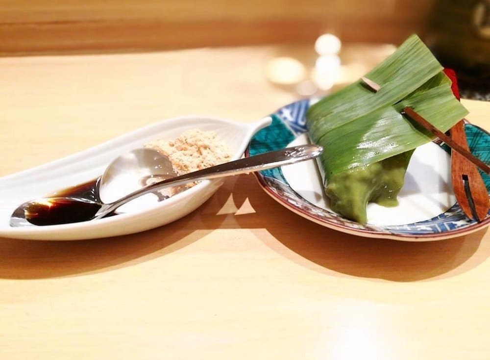 笹の葉に包まれた和菓子ときな粉を添えたデザート