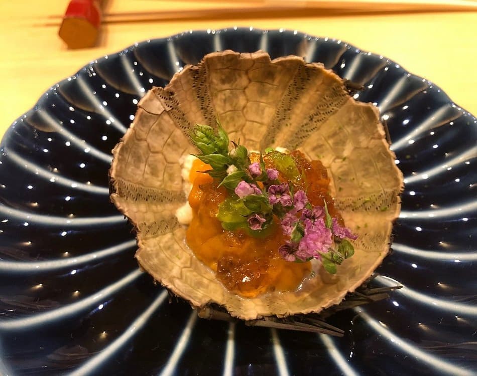 甲羅の器に海鮮と花穂を盛り付けたおまかせ料理