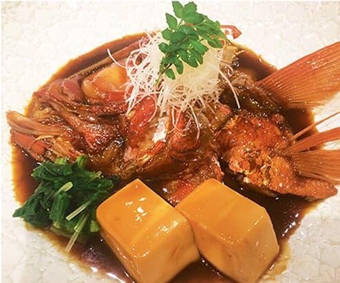 豆腐や青菜を添えた魚の煮付け