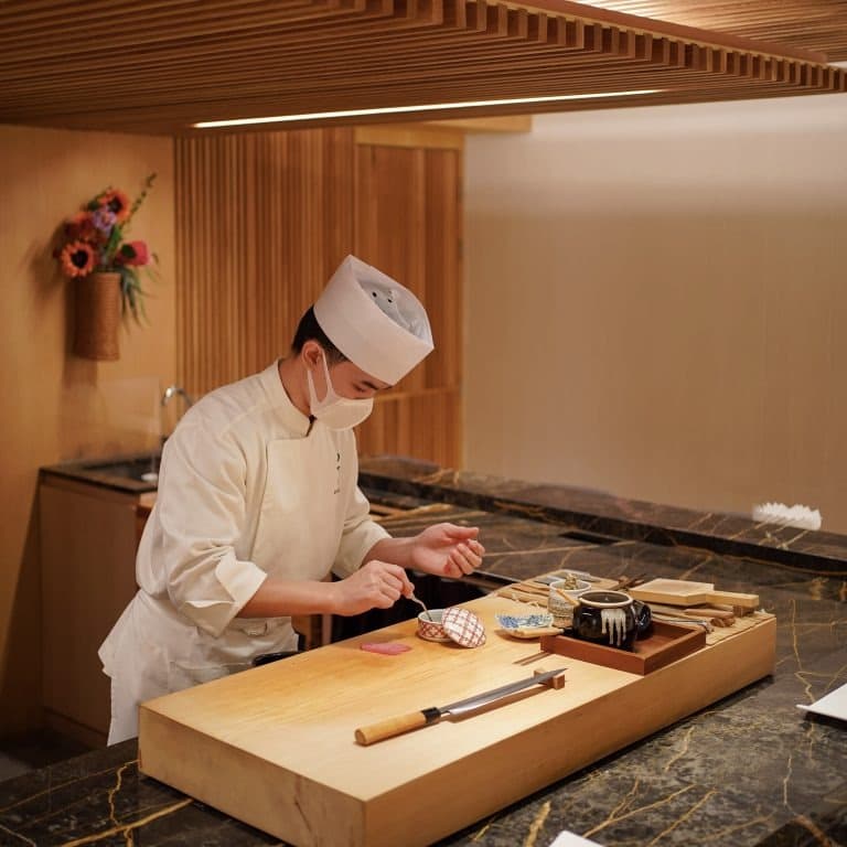 木を基調とした寿司カウンターで料理を仕上げるNOWAKI BKKの職人