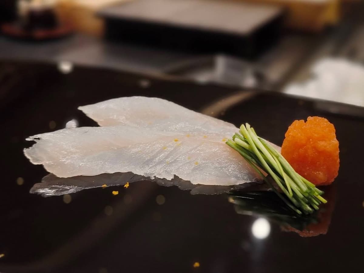 薄造りの白身魚に薬味を添えたSushi Kandaの一品料理