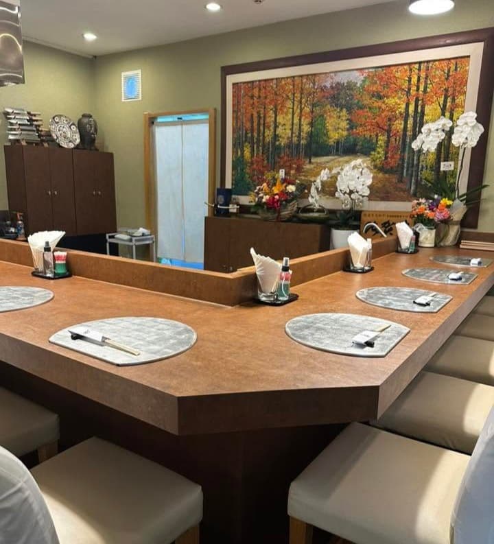 秋の風景画と生花が飾られた和食店のカウンター席