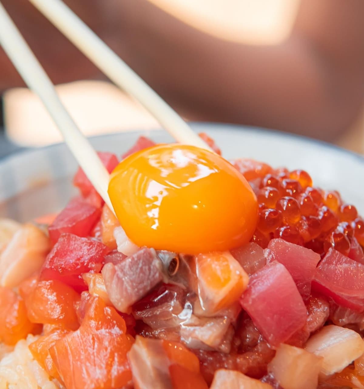 卵黄とイクラ、マグロやサーモンなどの刺身を盛り付けた海鮮丼