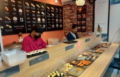 カジュアルな雰囲気で、様々な種類の寿司が並ぶ「スシ コーナー」の店内