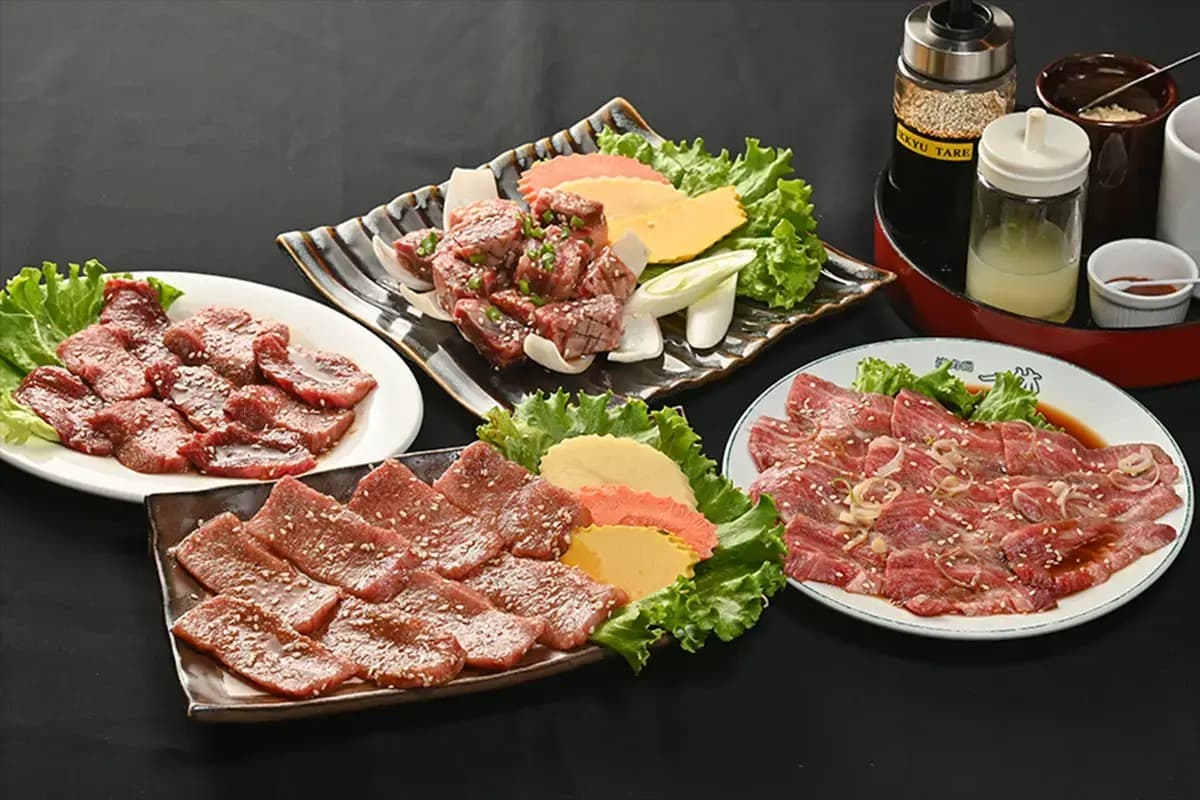 野菜やタレを添えた複数種類の焼肉用牛肉の盛り合わせ