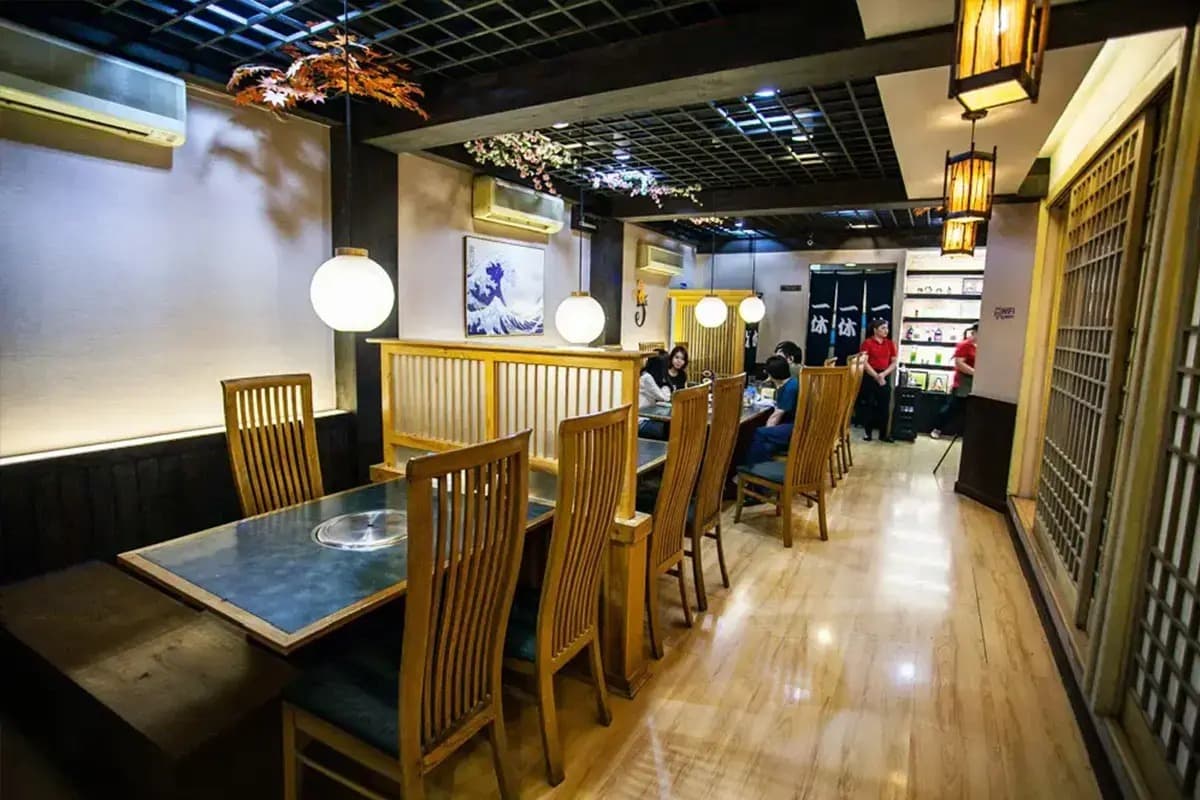 木製のテーブル席と仕切りが設けられた和風焼肉店の店内