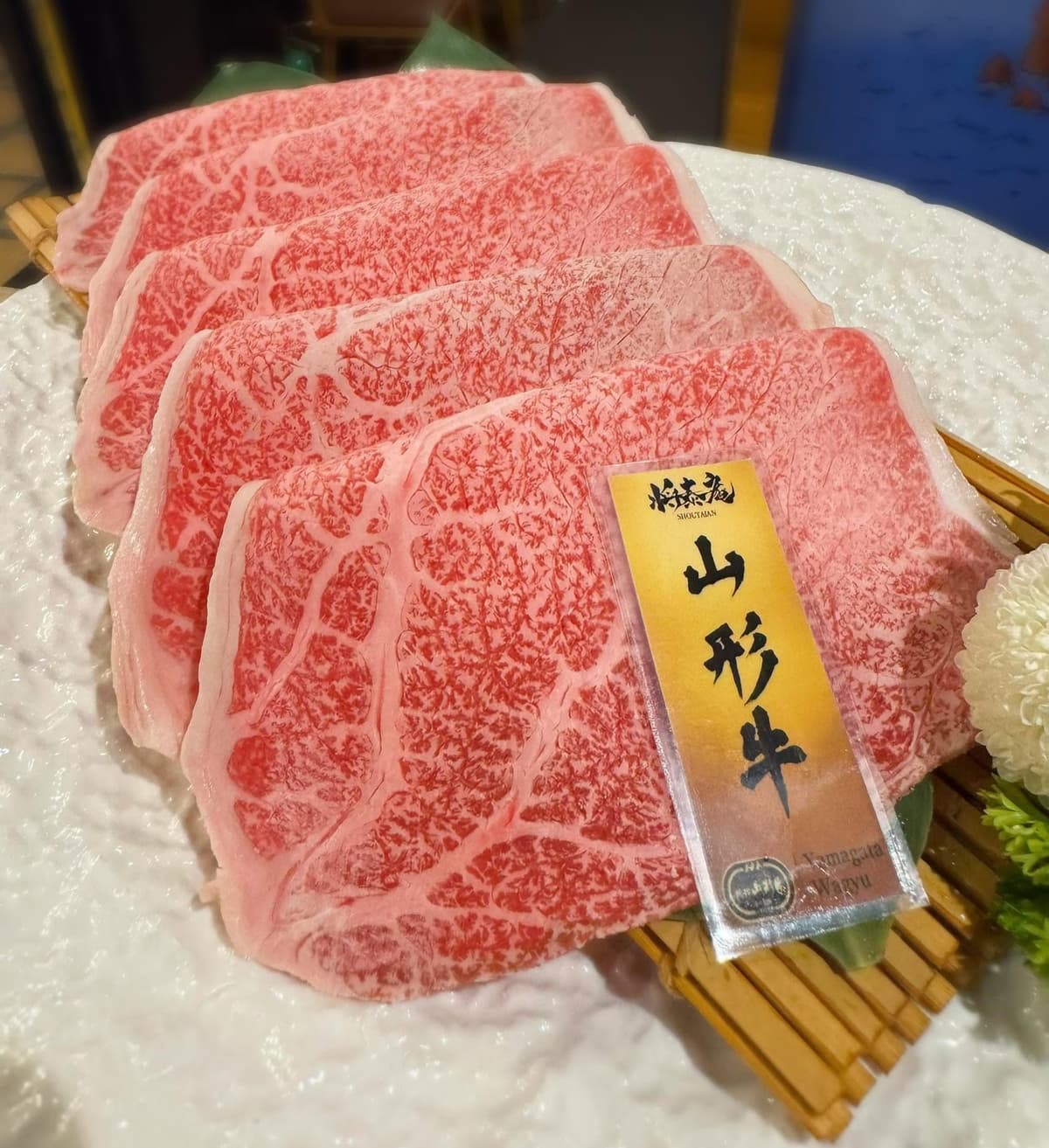 竹ざるに重ねて盛り付けた、鮮やかな霜降りの山形牛スライス