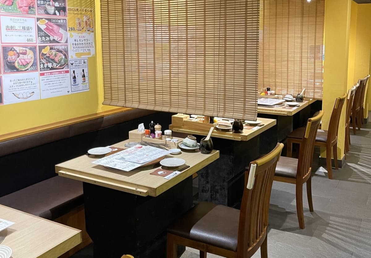 木製テーブルとベンチ席が並ぶ明るく落ち着いた焼肉店の店内