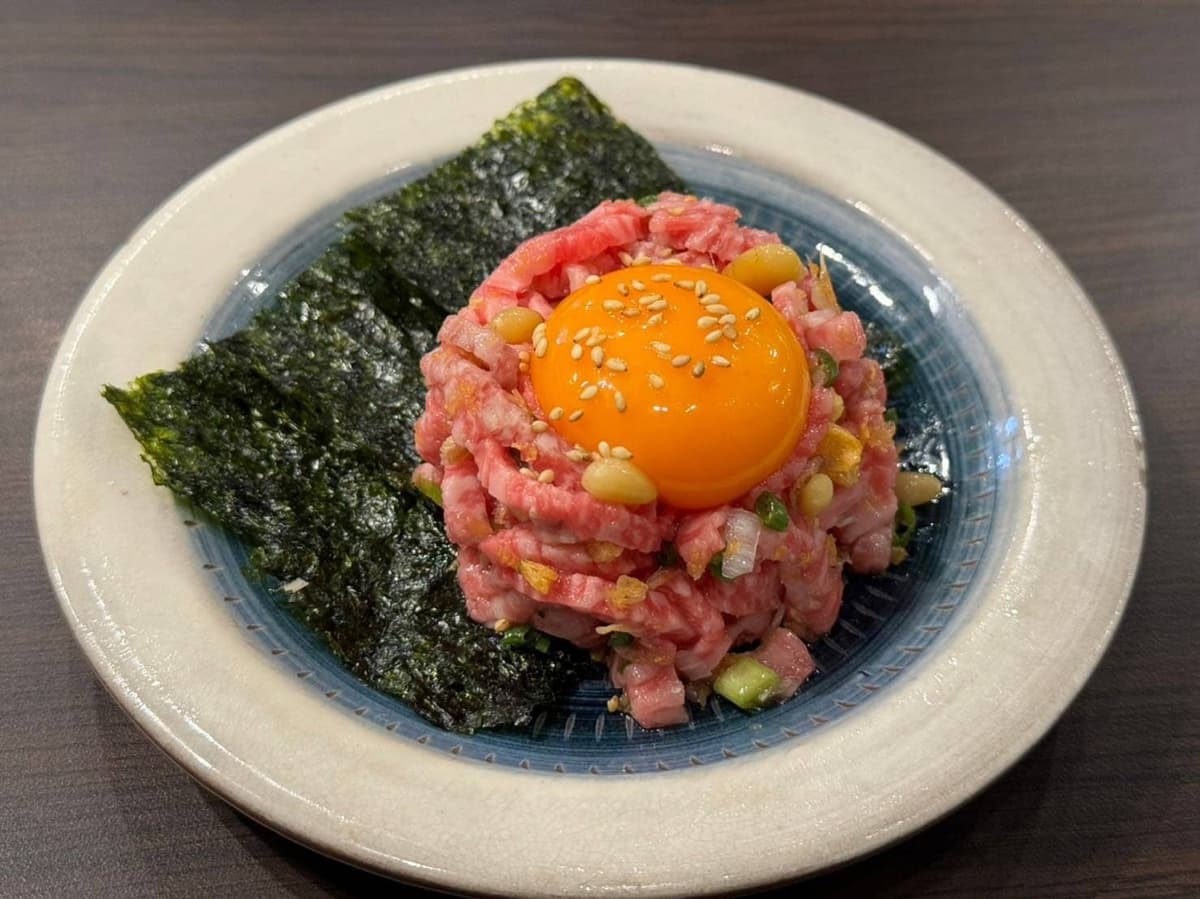 卵黄とゴマをのせ、海苔を添えたユッケ風の牛肉料理