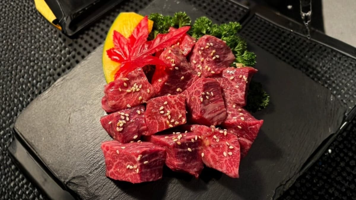 黒いプレートに盛り付けられた角切りの霜降り牛肉