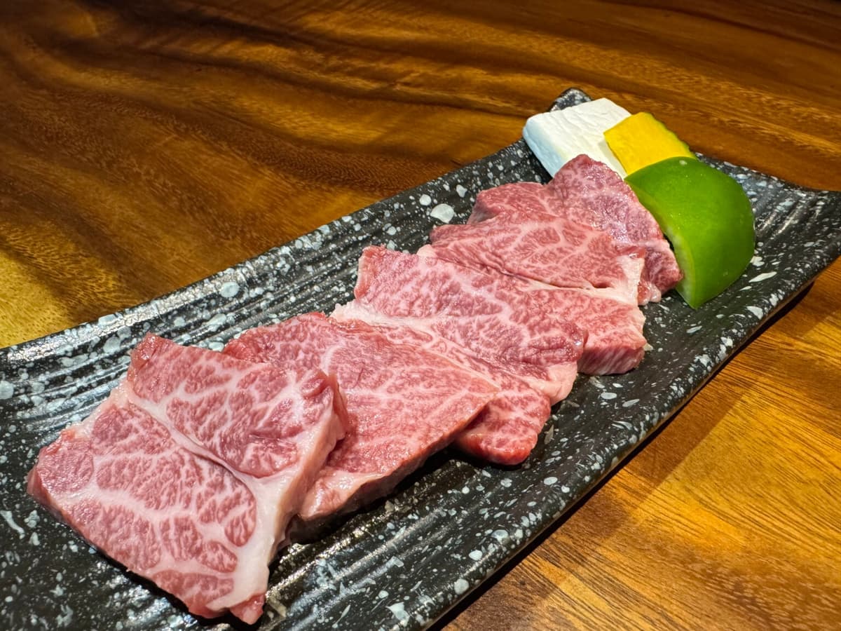 焼き野菜を添えた、きめ細かな霜降り牛肉の焼肉用スライス