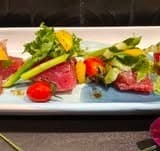 生肉とアスパラガス、トマトなどの彩り野菜を盛り付けた一皿