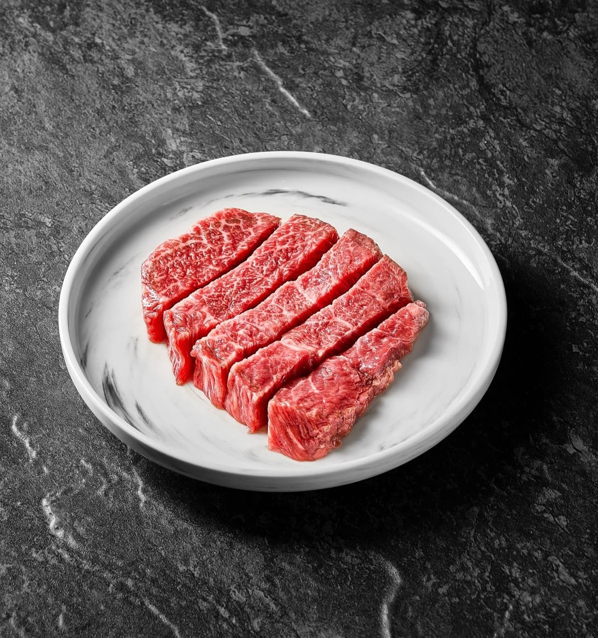 白い皿に盛られたサシの入った焼肉用牛肉