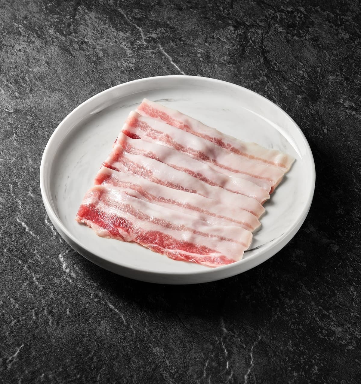 白い皿に盛られた薄切り豚肉のしゃぶしゃぶ用肉
