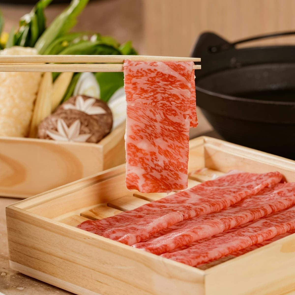 箸で持ち上げたShabubu ThonglorのA5和牛しゃぶしゃぶ肉