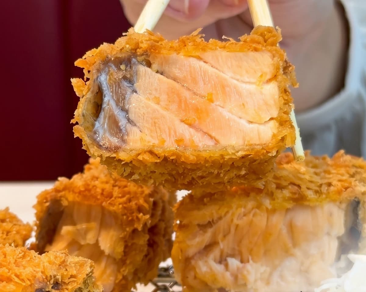 サーモンミルフィーユカツの断面を箸で持ち上げた様子