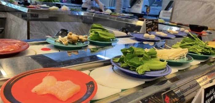 コンベアレーンを流れる新鮮な肉や色鮮やかな野菜など「しゃぶし」のバラエティ豊かな鍋具材