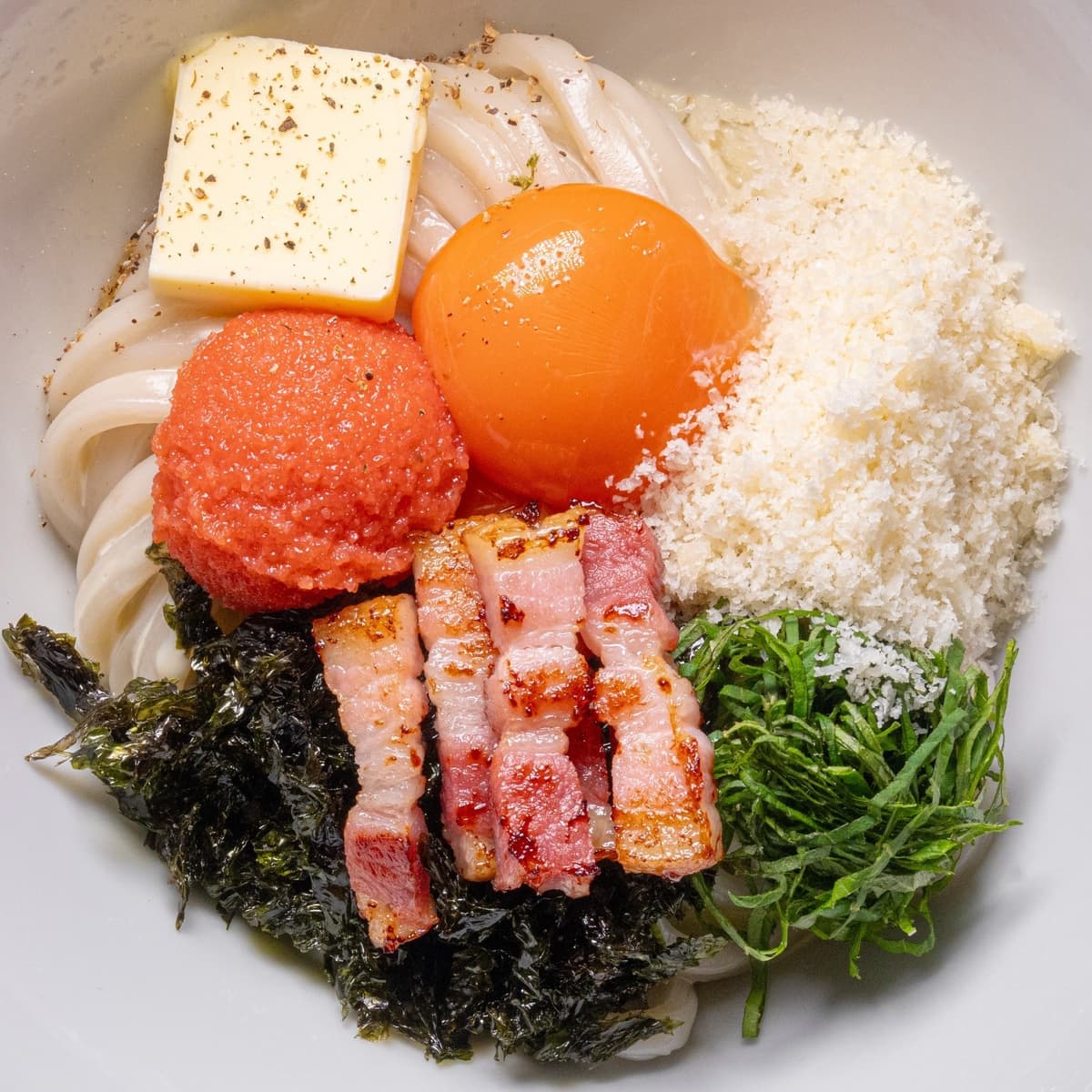 明太子や卵黄、チーズをのせたカルボナーラ風まぜうどん
