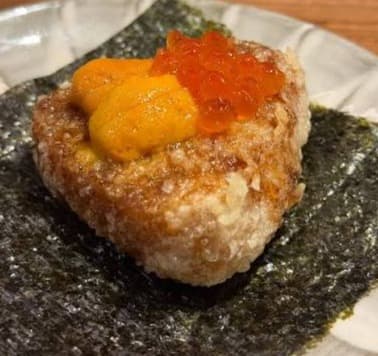 「天ぷらながおか エカマイ」の看板メニュー、サクサクの揚げおにぎりに、濃厚なウニといくらを贅沢にトッピングした一皿