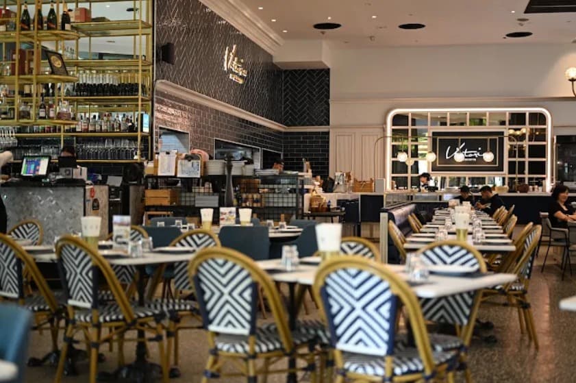 店内:モノトーンのインテリアのビクトリア バイ ココット エムクオーティエ店のテーブル席