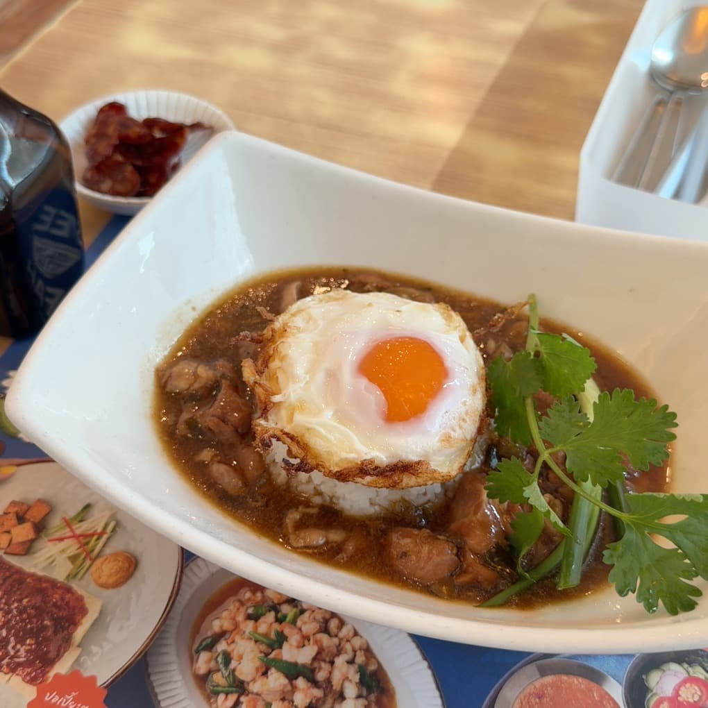 白い四角い深皿に盛られた、とろみのあるタレがかかったお肉とご飯。