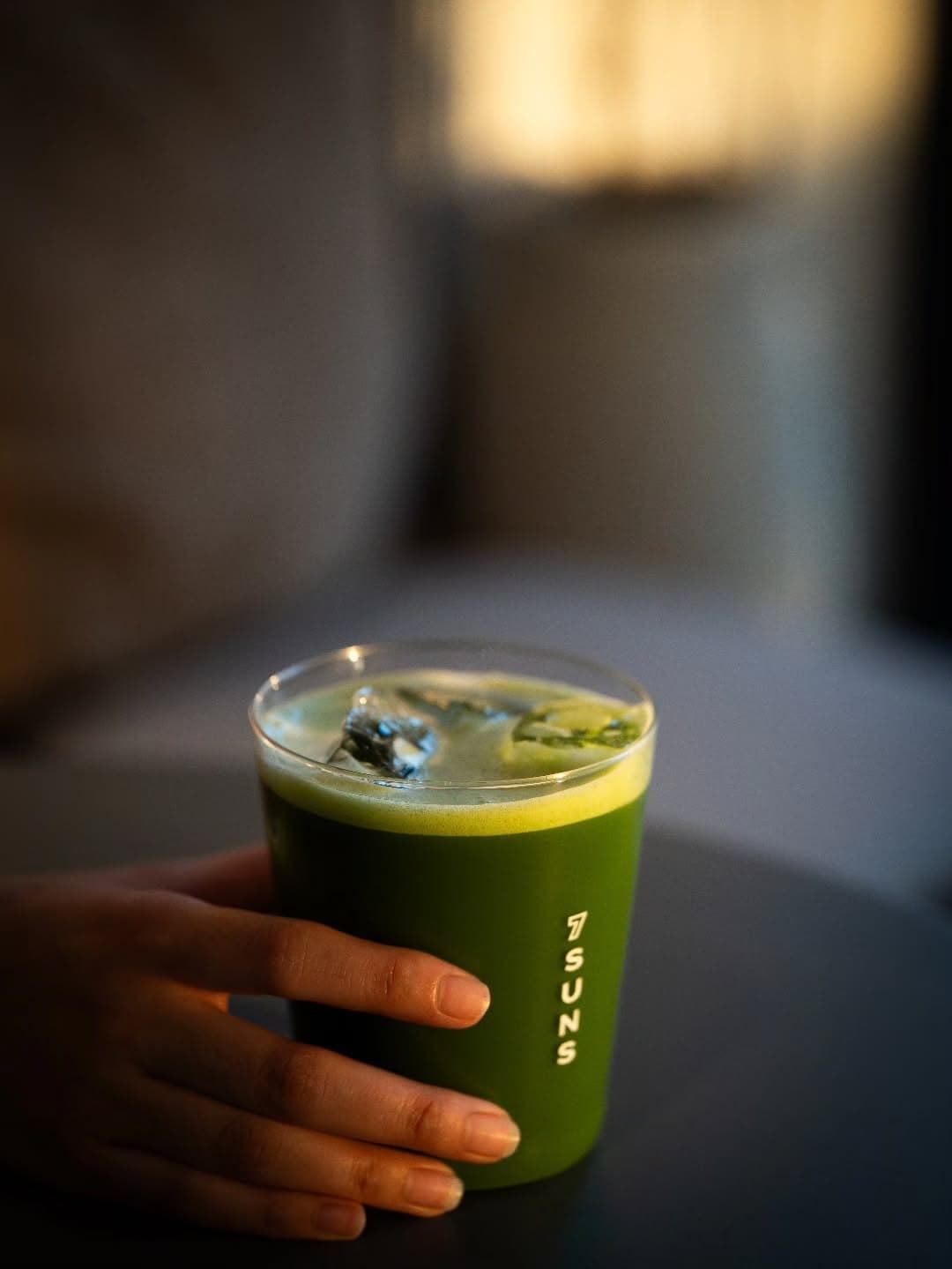 7SUNSのロゴ入りカップを手に持ったアイス抹茶ドリンク