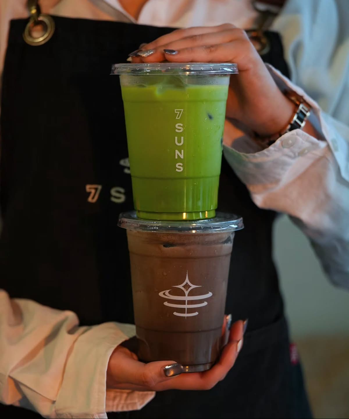 7SUNSの抹茶ドリンクとチョコレート系ドリンクを重ねて持つスタッフ