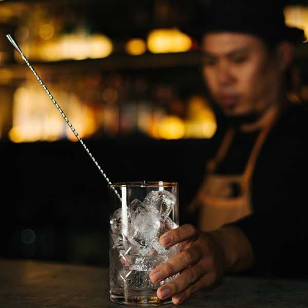 Black Cabin Bar Bangkokでカクテルを作るバーテンダー
