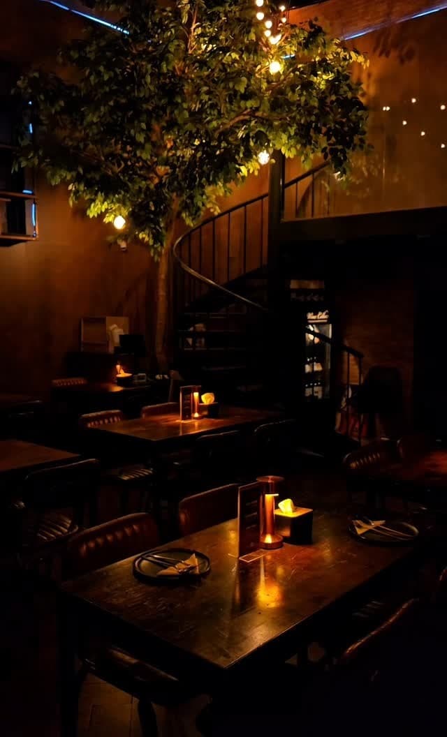 暖色の照明と螺旋階段が印象的なAnother Roundの店内