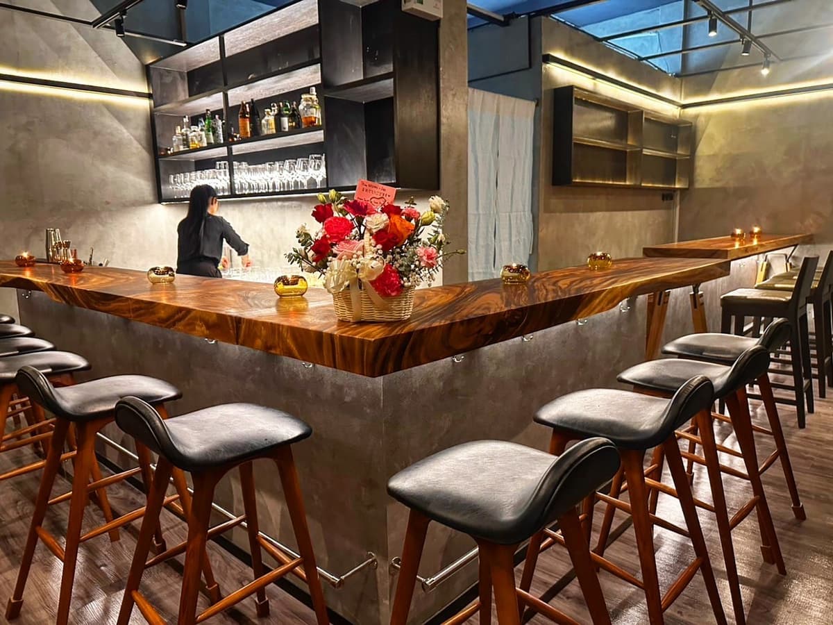 YUFU Bar(由布)の木製カウンターとハイチェアが並ぶモダンな店内