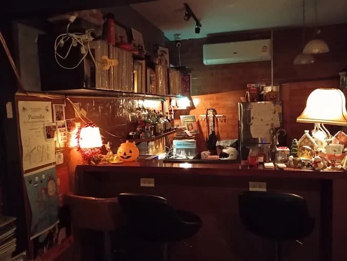 レトロなレコードや酒瓶が棚にぎっしりと並ぶ、木製の温かみがあるバーカウンター。
