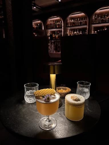 008 Barのテーブルに並ぶ2種類のカクテル、落ち着いた照明のバー店内