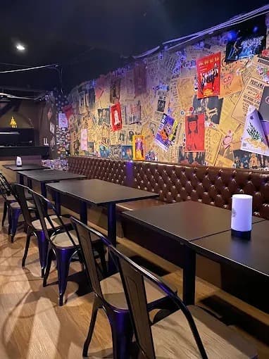 SHIN barのポスターで装飾された壁とソファ席の店内