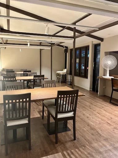 木製テーブルと椅子を配置した、Thonglor Rumbaの店内
