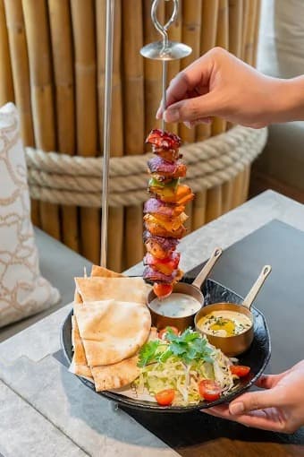 Lucca Thonglorの野菜と肉の串焼き、ピタパン、サラダ、ディップを盛り合わせたプレート
