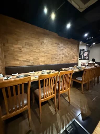 木目調のテーブルと卓上ロースターが並ぶ店内|Gyu-Kaku Japanese BBQ