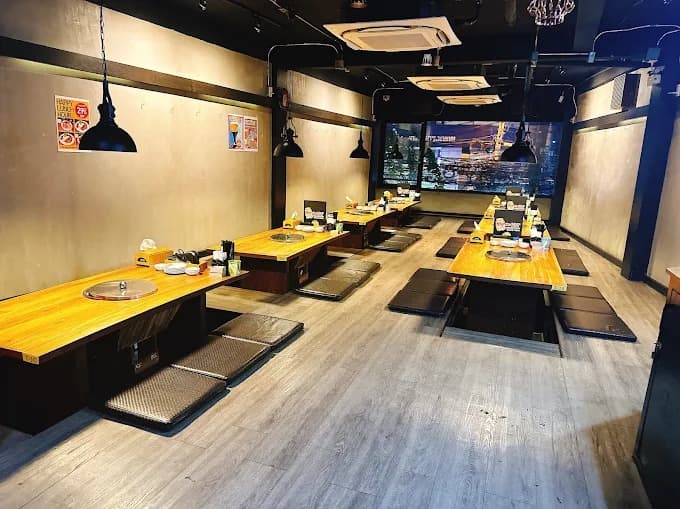 焼肉用ロースター付きテーブルが並ぶNikusho Thaniyaの店内